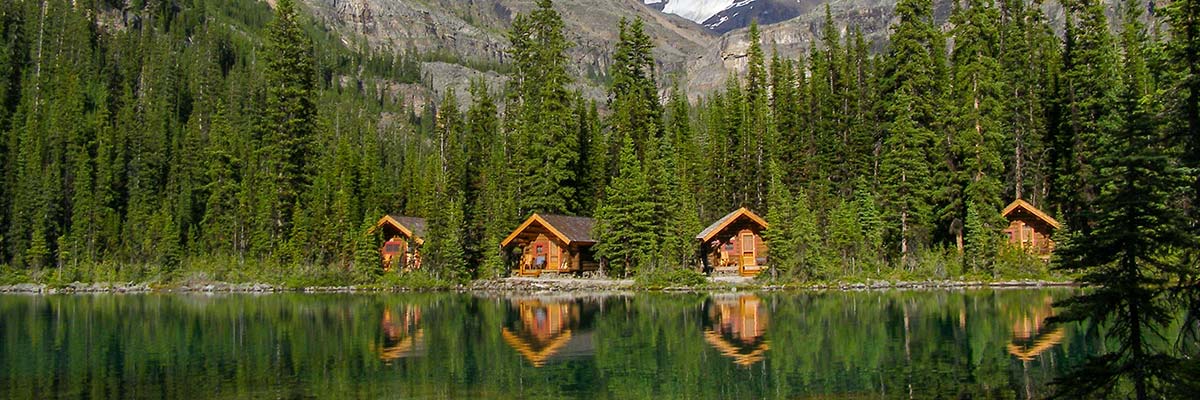 Les chalets du complexe Lake O’Hara Lodge voient leur reflet dans les eaux calmes du lac O’Hara.