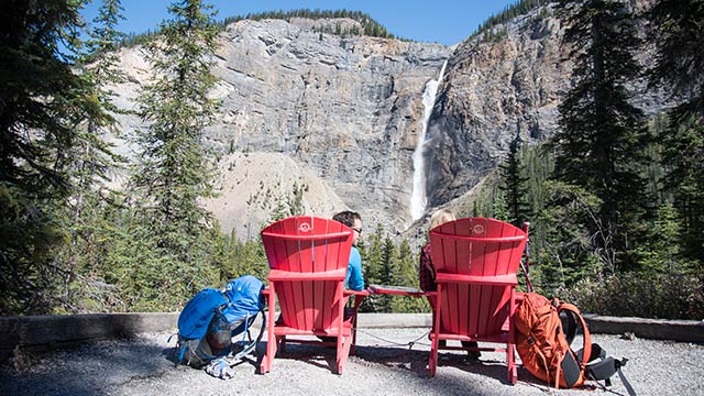 Deux visiteurs assis sur des chaises rouges