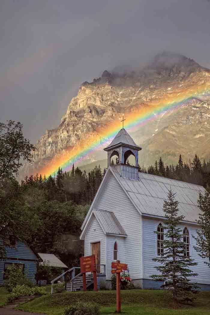 St. Joseph’s Catholic Church with a rainbow and view of Mt. Stephen
