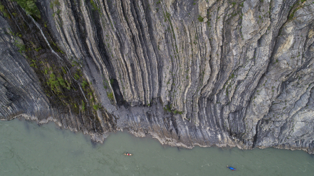 Aerial view of Teetł’it Gwinjik (Peel River) canyon with canoeists.