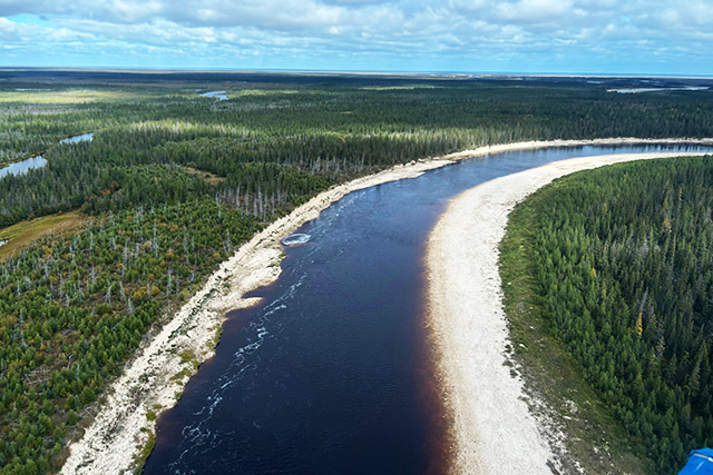 An aerial view of a river curving to the right.