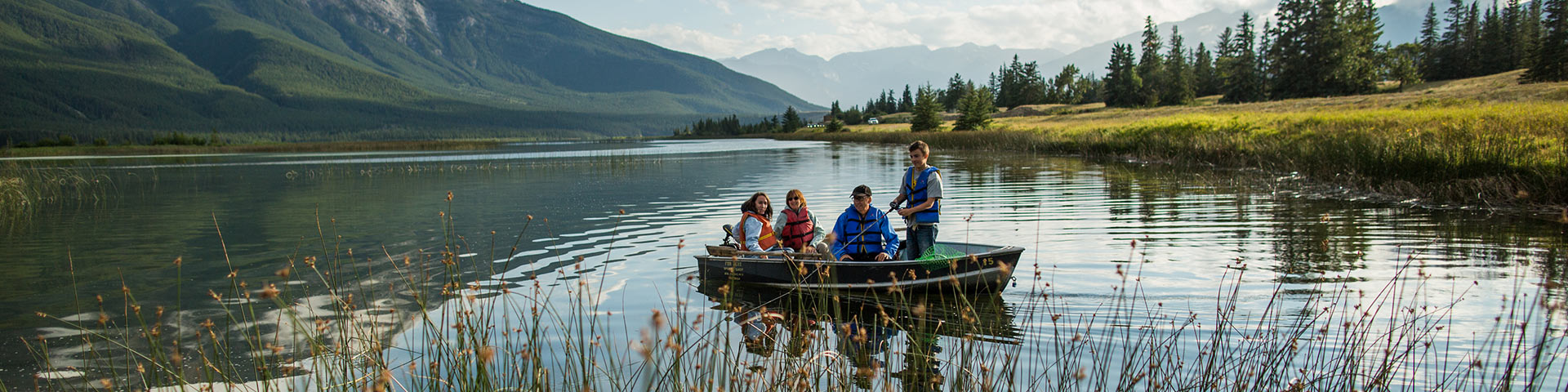 Family fishing from a boat on a mountain lake
