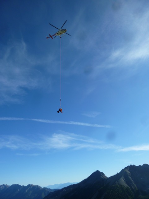 A Visitor Safety Specialist slings the injured hiker to the staging area