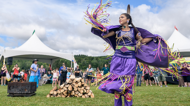 An indigenous woman does a traditional dance