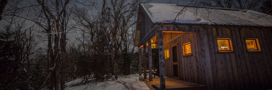 Un chalet rustique en hiver, la nuit