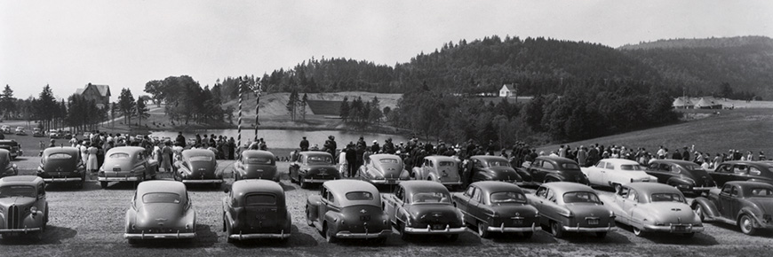 Plusieurs vieilles voitures stationnées près de l'étang McLaren dans les années 1950.