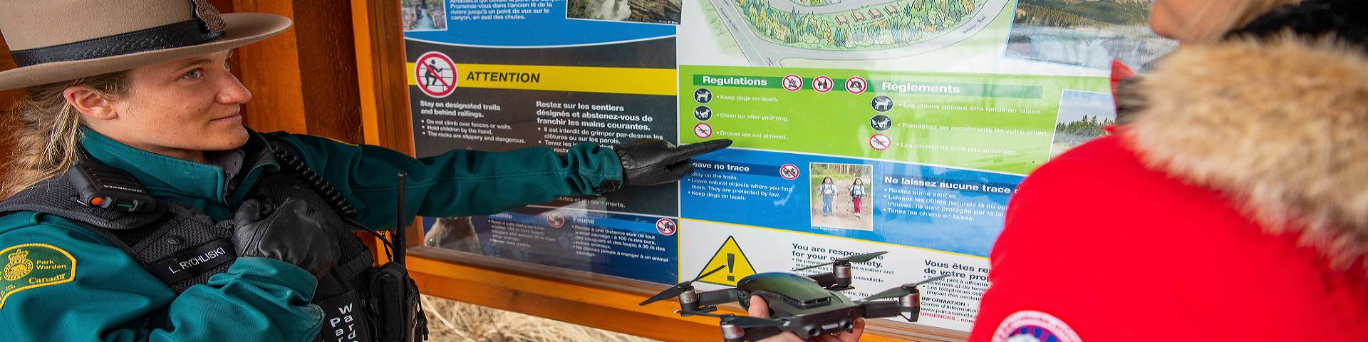Un gardien de parc explique à un visiteur que les drones sont interdits