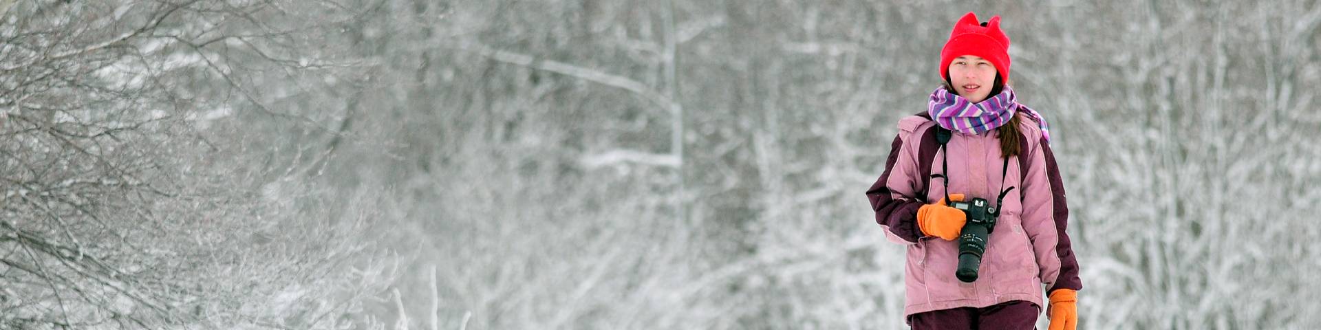 a person in a winter jacket with a camera