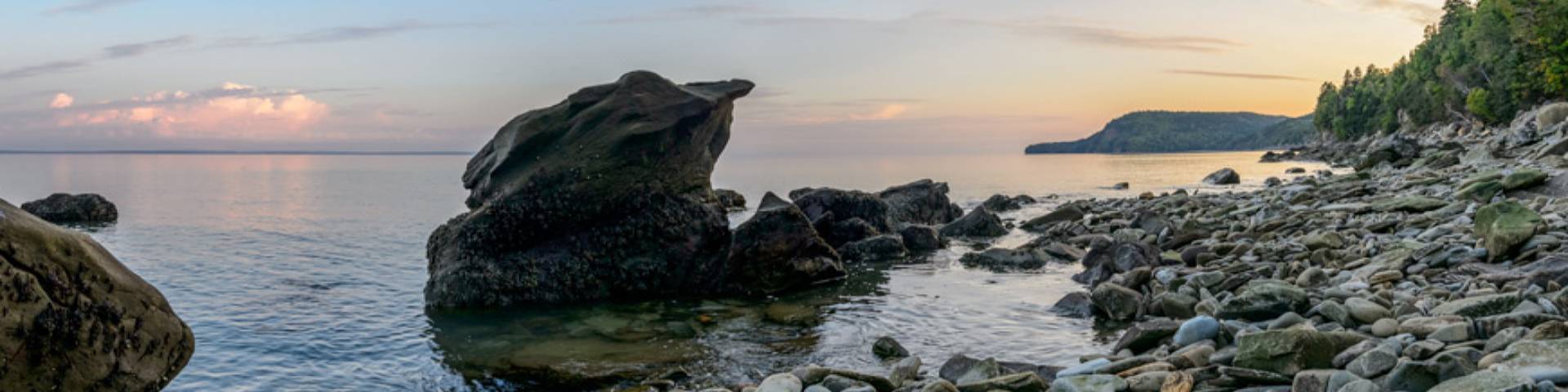 A landscape of rocks in the water on the side of a bank