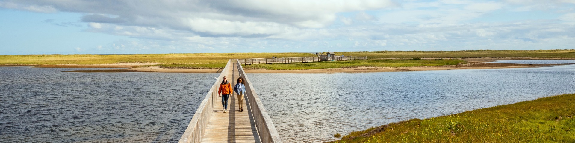Un couple marche sur la passerelle à la plage Kellys