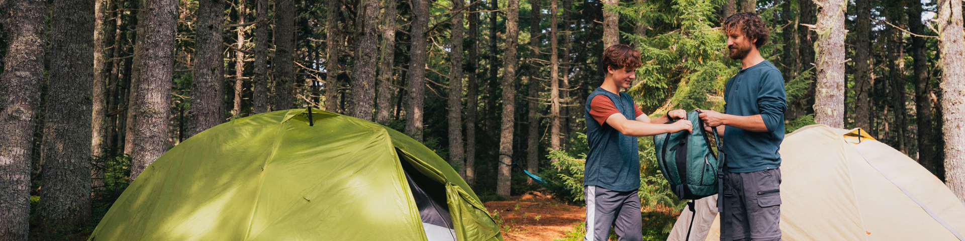 Père et fils près de leur tente dans le terrain de camping