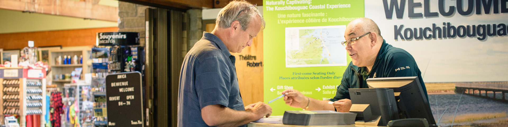 A Parks Canada staff member talks to a visitor at the reception desk