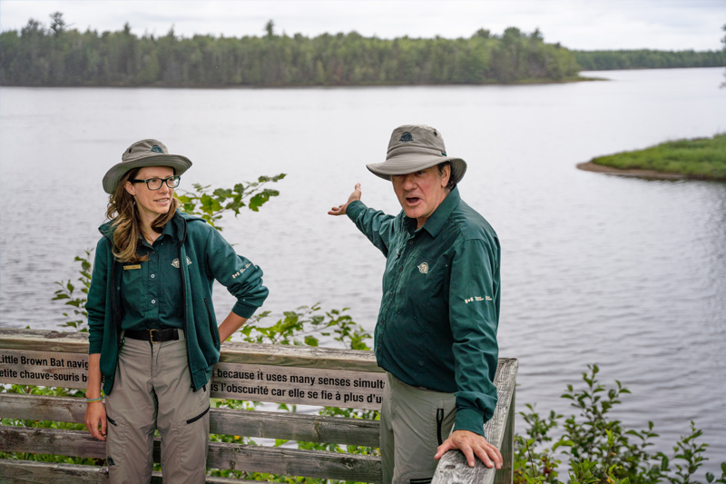 Two Parks Canada interpreters standing near a river.