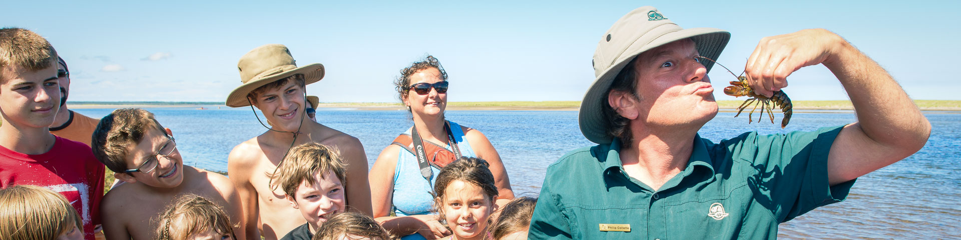 A Parks Canada Interpreter speaking to a group by the beach