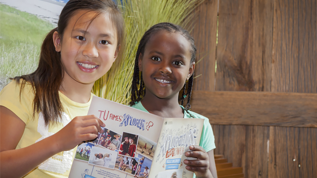 Children holding a Parks Canada Xplorers booklet