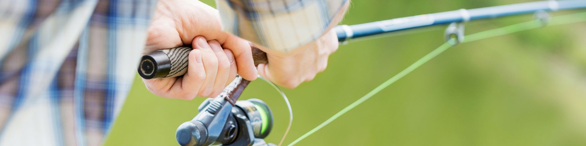 Closeup view of someone holding a fishing rod.