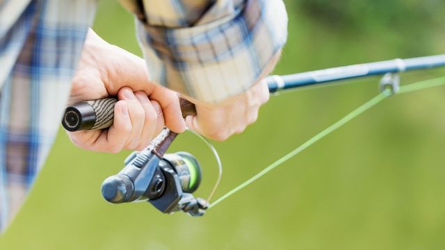 Closeup view of a person holding a fishing rod.