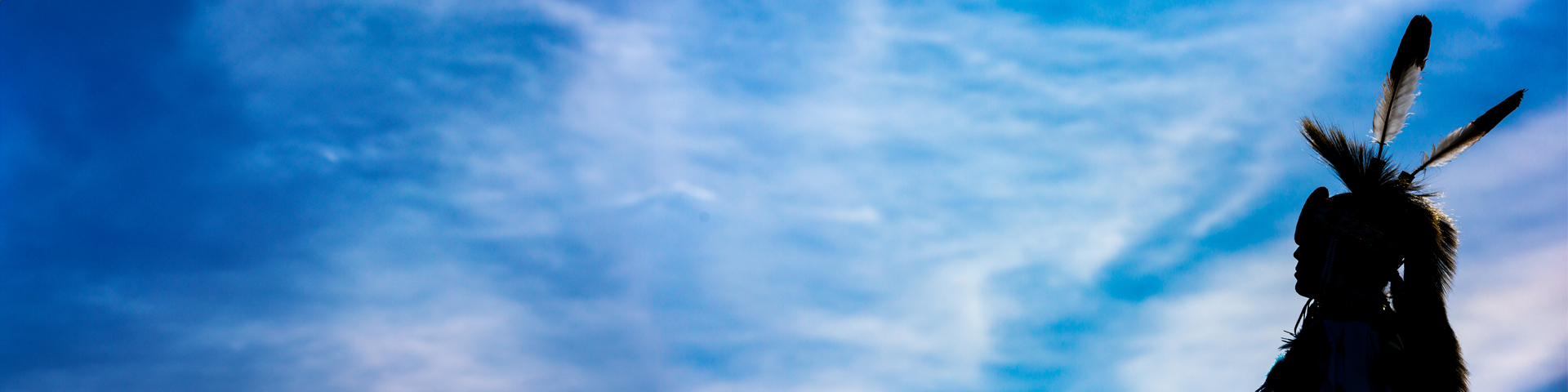 Silhouette d'une personne autochtone devant un ciel bleu