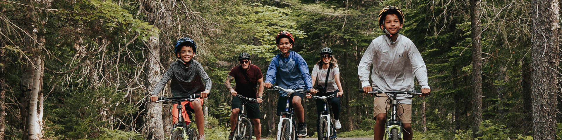 A family cycling on a trail in the forest.