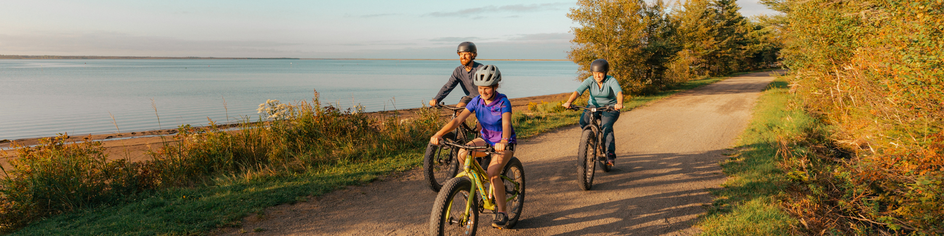 A family cycling on a trail near a body of water