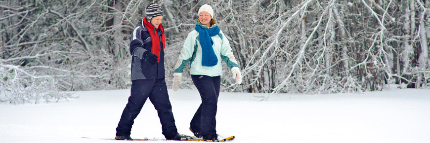 Two friends snowshoeing in the forest