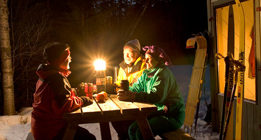 People sitting at a picnic table outside the shelter.