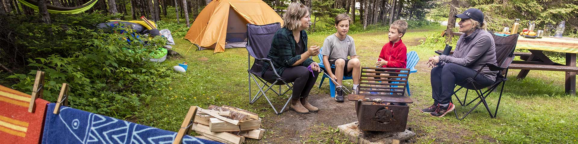 People sitting around a campfire in Shallow Bay campground