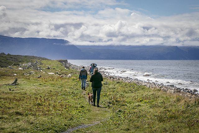 People walking along the shoreline of the Coastal Trail in Gros Morne National Park