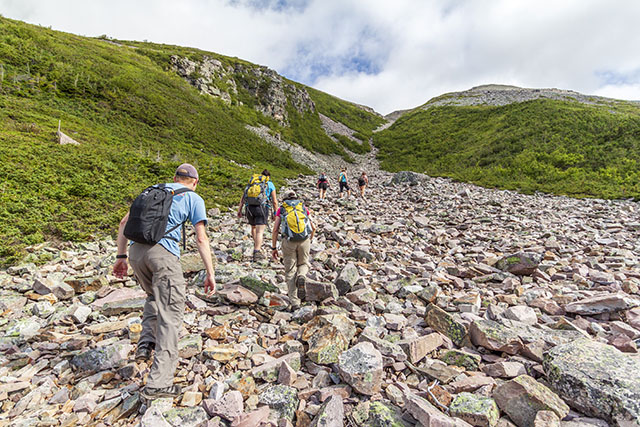 People hiking the rocky summit of Gros Morne Mountain in Gros Morne National Park