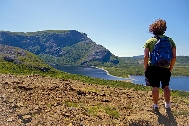 A hiker enjoying the view of Trout River Pond in Gros Morne National Park