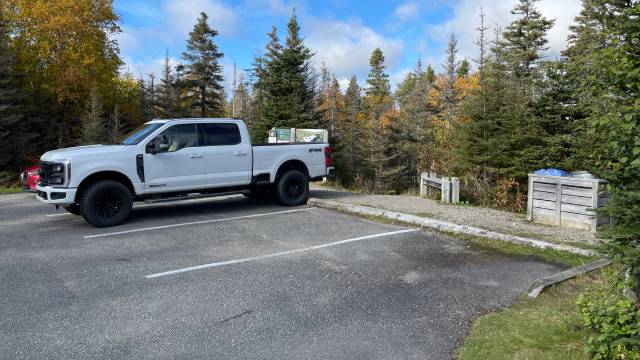 A white truck in a parking lot with high curbs.