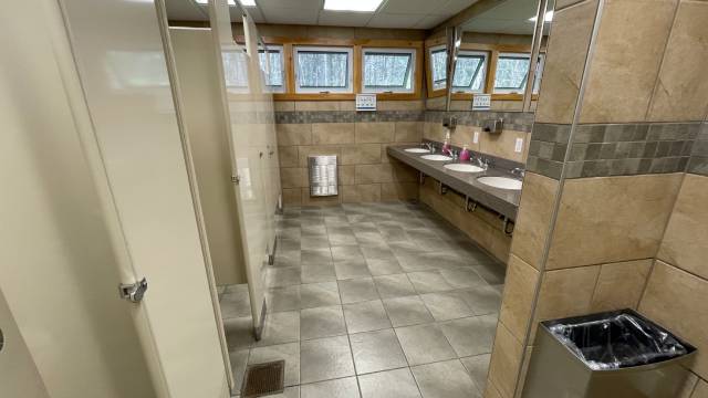 A bathroom with sinks and toilet stalls.