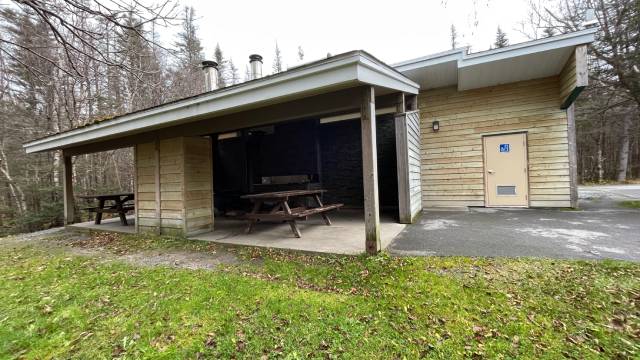 A building with a covered patio with picnic tables