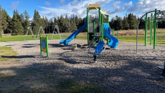 A playground with blue slides and swings.