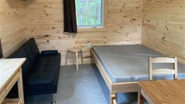 Interior of cabin with a bed and couch.
