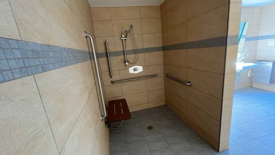 A roll-in shower with a bench and grab bars