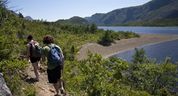 Two people walking along a water-side path