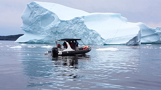 un bateau de tourisme à côté d'un iceberg