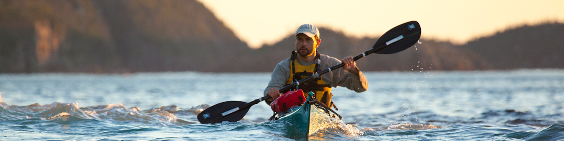 a man kayaking on the ocean