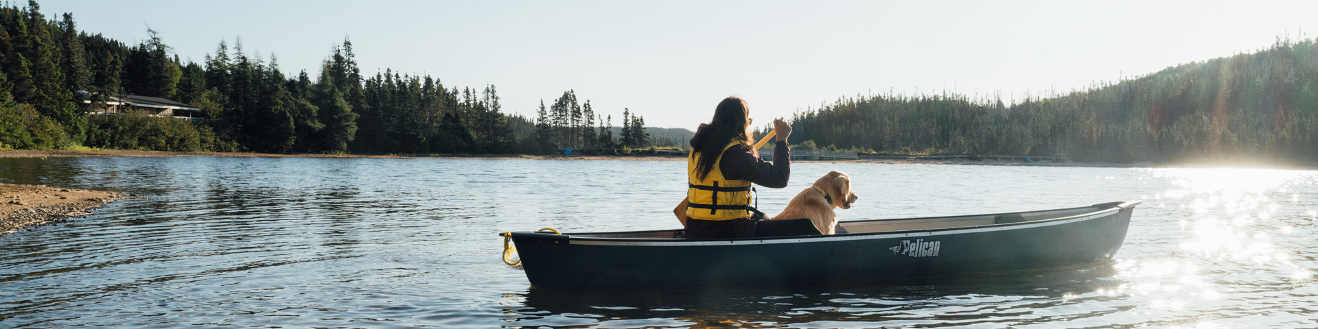 un individu et un chien dans un canoë sur un étang