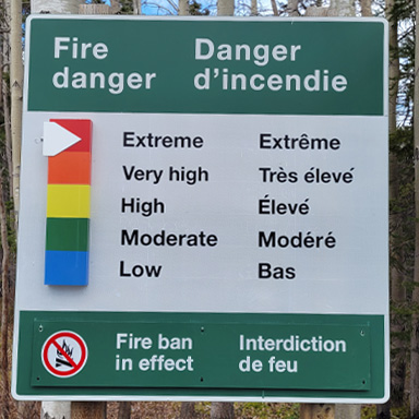 Close-up of a sign indicating various fire danger levels from extreme to low.