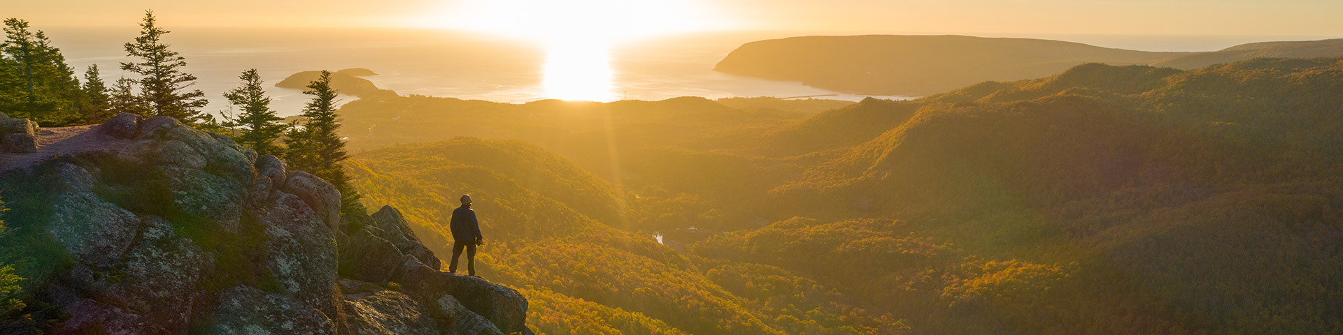 Une personne regardant le coucher du soleil au parc national des Hautes-Terres-du-Cap-Breton