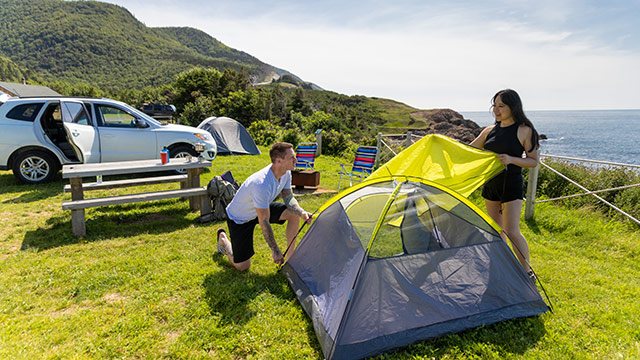 Deux personnes installant une tente dans le parc national des Hautes-Terres-du-Cap-Breton