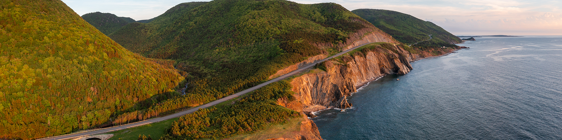 A photograph of rolling hills and the Atlantic Ocean along the Cabot Trail. 