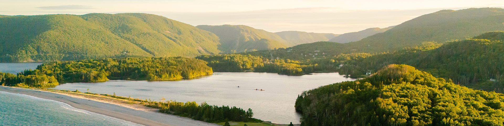 Trois personnes pagayant en kayak sur un lac d'eau douce.