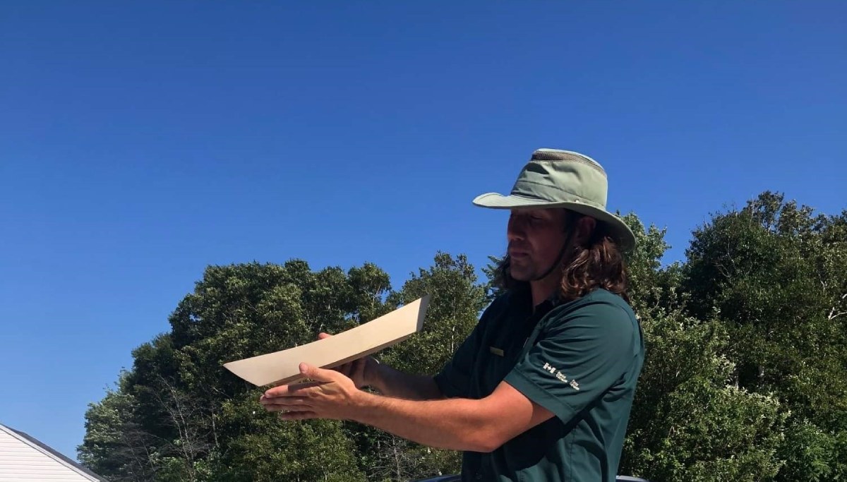 A Parks Canada interpreter holds a miniature dory.