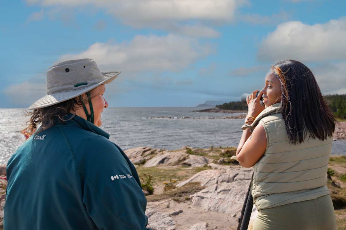 Un interprète de Parcs Canada et un visiteur regardent la mer depuis l’anse Green.