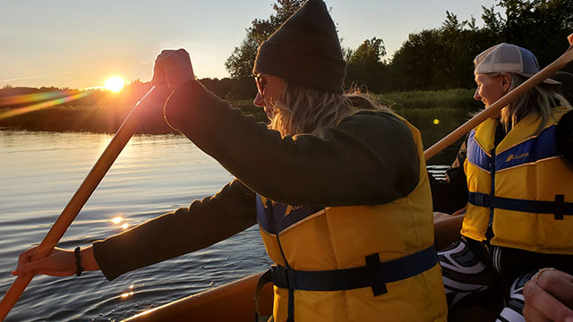 Two people in a canoe at sunset.