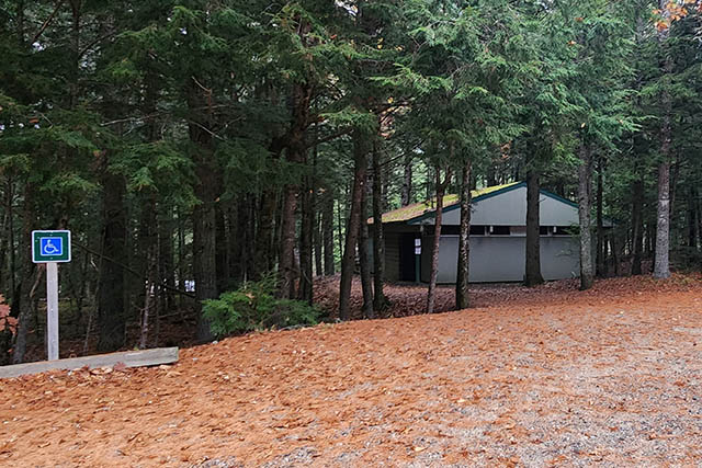 An accessible parking spot near the picnic shelter; the ground is covered with leaves.