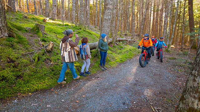 Des personnes en randonnée et à vélo se croisent sur un sentier de gravier.